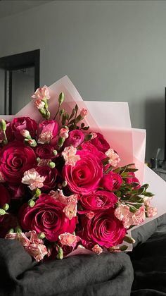 a bouquet of pink roses sitting on top of a bed