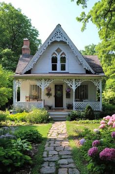 a white house surrounded by flowers and greenery