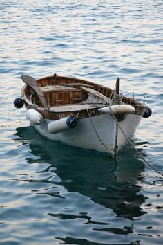 a small boat floating on top of a body of water