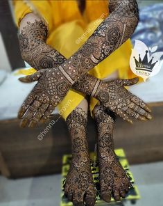 henna tattoos on the hands and feet of a woman with yellow ribbons around her ankles