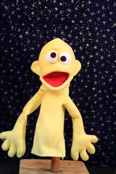 the sesame character is posed on top of a wooden stand with stars in the background