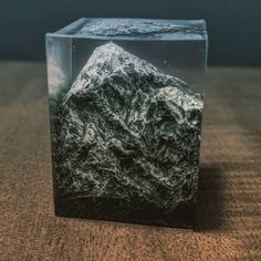 a black and white photo of a rock in a glass block