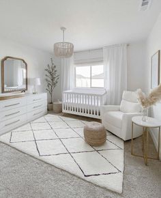 a baby's room with a white crib, dresser and chair in it