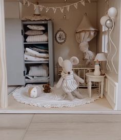 there is a doll house with white furniture and accessories in the room, including a teddy bear