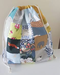 a bag made out of fabric with animals and other things on the front, sitting on top of a table