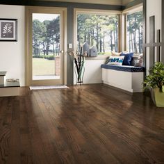 a living room with hardwood floors and large windows