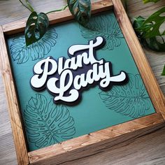 there is a sign that says plant lady on the side of a wooden frame with plants in the background