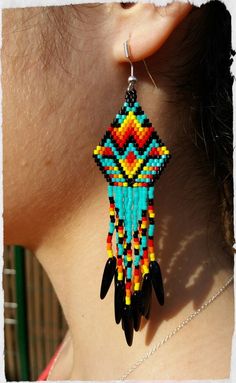 a close up of a woman's ear wearing colorful beaded earrings with black beads