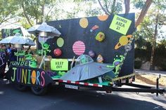 a trailer with some decorations on the back and people standing around in front of it