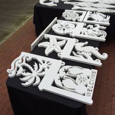 several tables with black and white tablecloths are lined up on a brick sidewalk