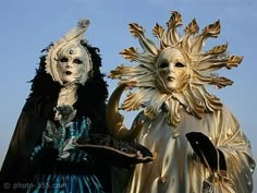 two people in costumes standing next to each other with masks on their faces and hands