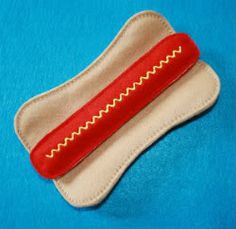 a red hot dog on top of a white cloth covered case with a blue background