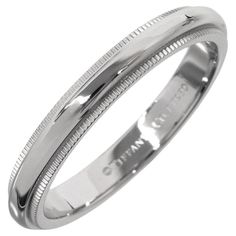 a white gold wedding ring with engraved details