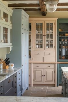 A rustic, farmhouse-style kitchen with a mix of wood and white cabinets, exposed wooden beams, and a large farmhouse-style sink. Kitchen Cabinet Ideas, Cabinet Ideas, Cozy Kitchen, Color Ideas