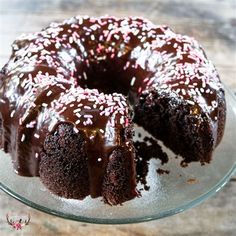 a bundt cake with chocolate frosting and sprinkles on a glass plate