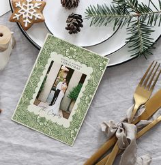 a table topped with plates and silverware next to a christmas tree ornament