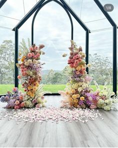 an arch is decorated with flowers and petals