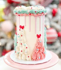 a cake decorated with pink, blue and white icing on top of a table