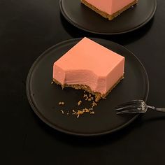 two black plates with desserts on them, one has a slice missing from it