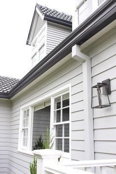 a house with white siding and black roof