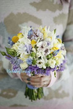 a woman holding a bouquet of flowers in her hands