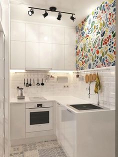 a kitchen with white cabinets and floral wallpaper on the walls is pictured in this image