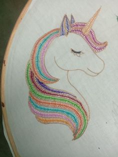 an embroidered unicorn's head on a white background