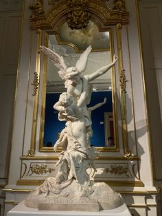 a statue is shown in front of a mirror with an angel on it's back