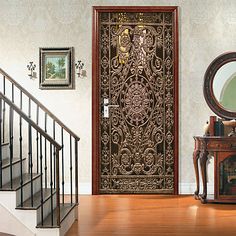 an ornate wooden door in the middle of a room with white walls and wood floors