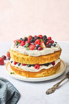 a cake on a plate with berries and whipped cream