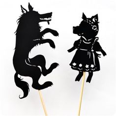 two cupcake toppers with black paper cutouts of dogs and girls on them