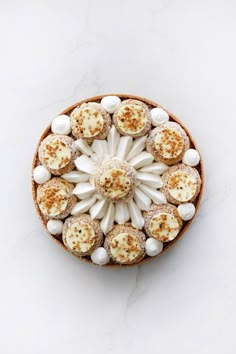 a cake with white frosting and marshmallows in it on a table