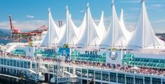 a cruise ship with many sails on it's roof and people walking around the deck