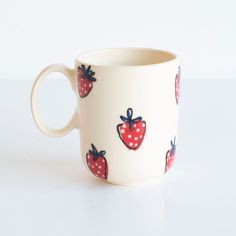 a cup with strawberries painted on it