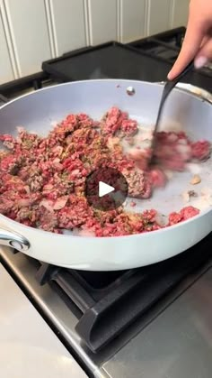 someone is cooking food in a pan on top of the stove with a spatula