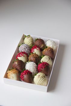 a white box filled with chocolate covered strawberries