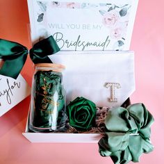 the bridesmaid gift box is filled with green roses and personalized gifts for her