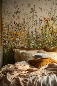 a bed sitting in front of a wall with wildflowers on it