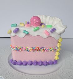 a pink cake with white frosting and sprinkles on it's side