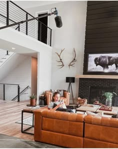 a living room filled with furniture and a fire place next to a stair case in front of a window