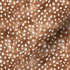 an animal print fabric with white spots on brown and beige background, suitable for use in clothing