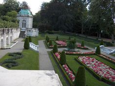 the garden is full of beautiful flowers and greenery, including boxwood topiary