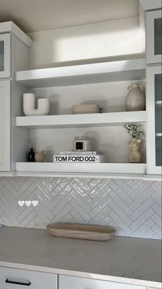 a kitchen with white cabinets and counter tops