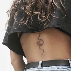 the back of a woman's stomach with a snake tattoo on her left side