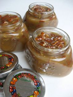 four jars filled with food sitting on top of a table