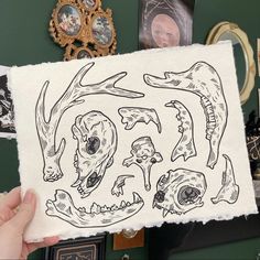 a person holding up a piece of paper with drawings on it