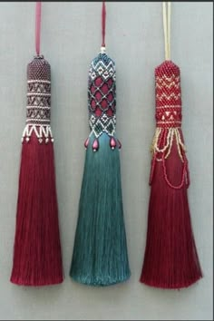 three tassels hanging from strings on a wall