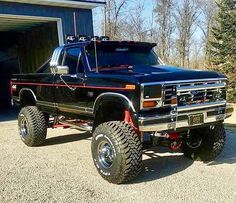 a black truck parked in front of a garage