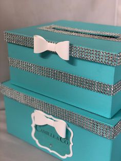 two blue boxes with bows on them sitting on a table