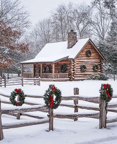 a log cabin with wreaths on the fence